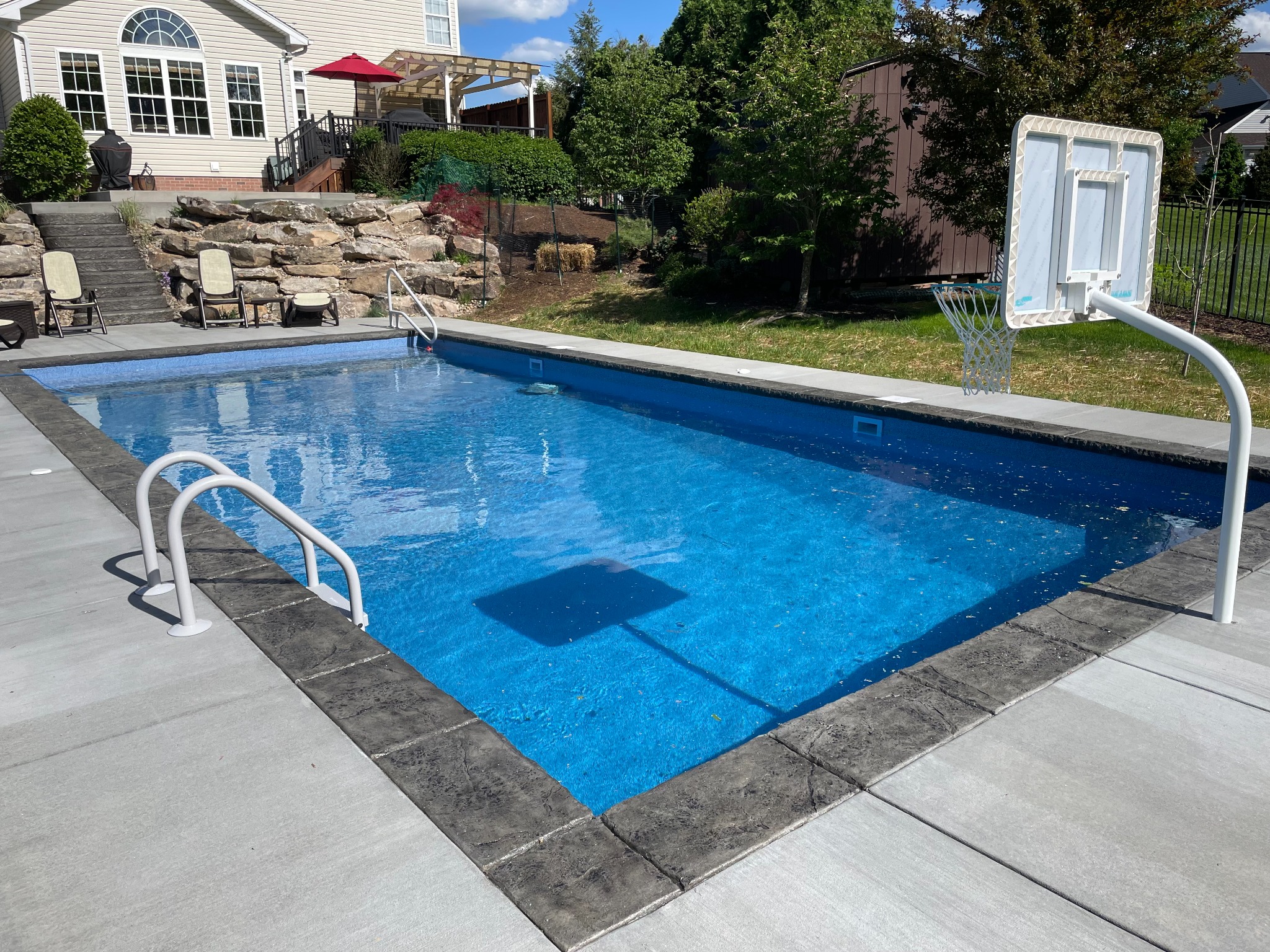 Rectangular pool with clean deck lines and seating area